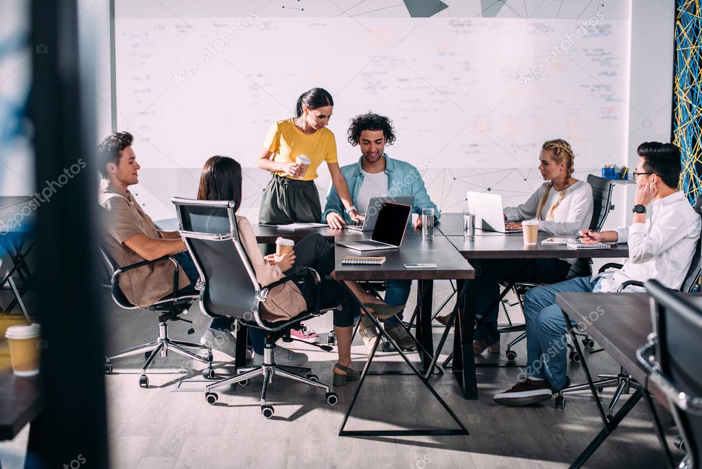 Team collaborating in a modern office meeting room with large display